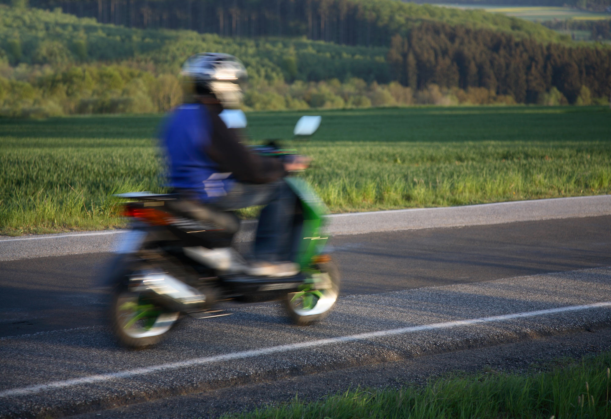 Moped som kör på en väg
