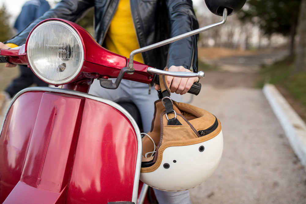 Röd moped som en kvinna kör